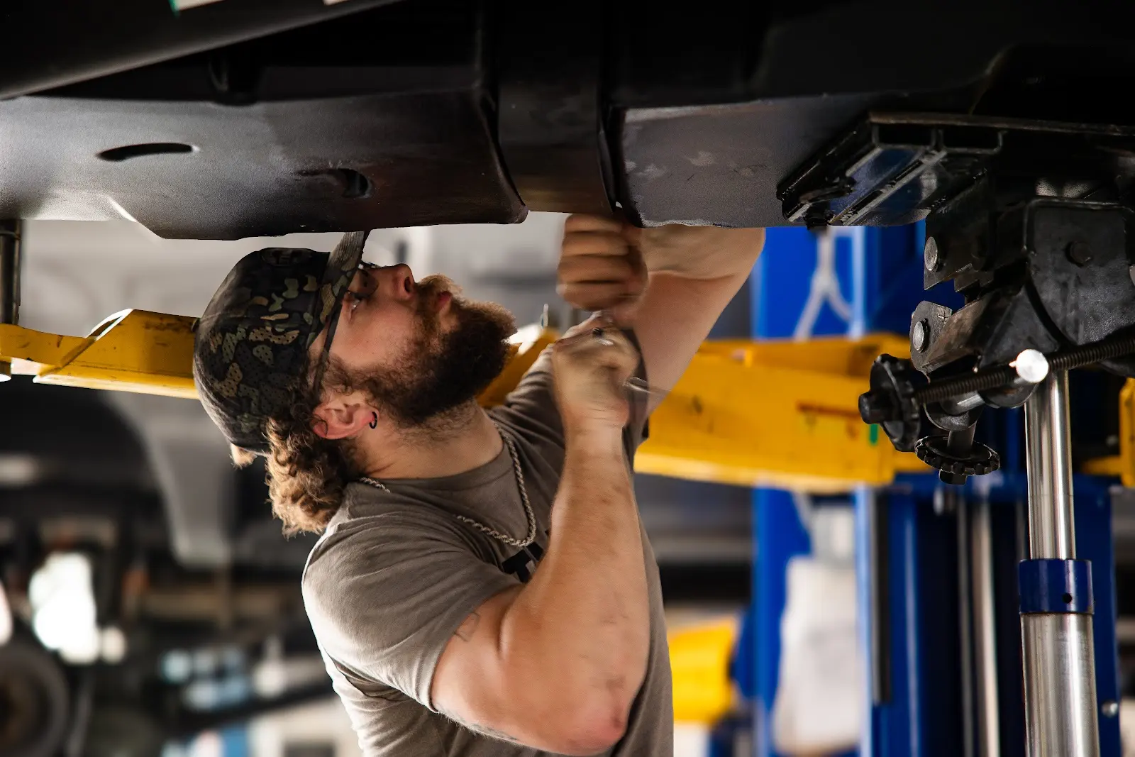Undercarriage Repair Services Expert mechanic inspecting truck undercarriage and repair frame